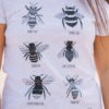Close up of a model wearing light grey T-shirt with bees
