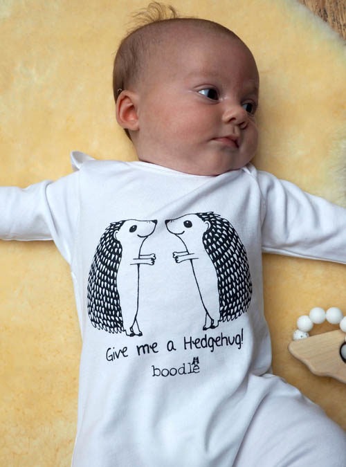 Cute baby wearing an organic cotton hedgehog baby grow perfect for animal loving parents!