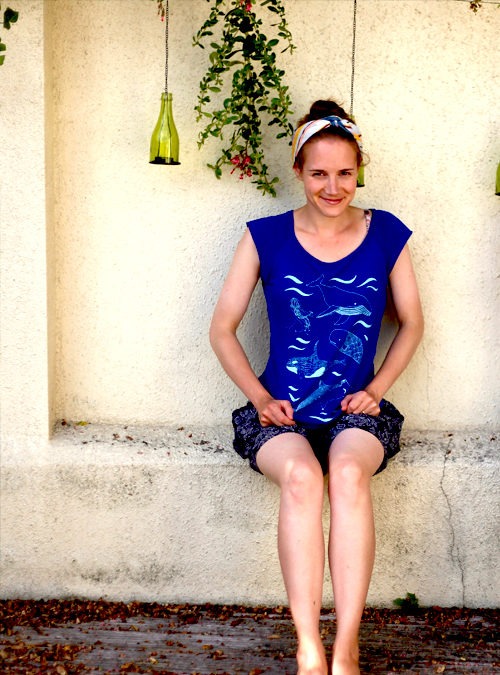 Model wearing blue under the sea T-shirt featuring Whales, sharks, starfish and waves