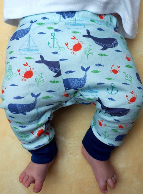 Baby wearing nautical baby leggings featuring whales, crabs, boats and jellyfish