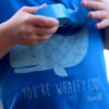 close up of whaley cool kids t-shirt. Blue T-shirt featuring a cute illustration of a whale