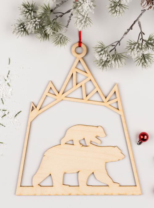 Polar bear wooden decoration feeaturing a mum and baby polar bear underneath a mountain. Laser cut from birch ply.