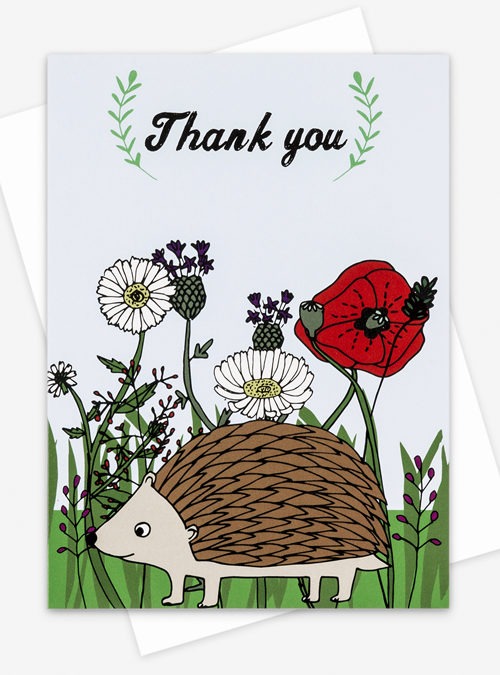 Hedgehog greetings card featuring an illustration of a hedgehog with british flowers in the background and the text 'Thank you' above