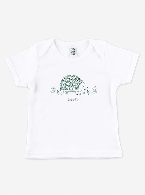 photo of a white organic cotton T-shirt featuring a green screen print of a hedgehog surrounded by foliage