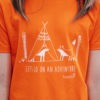 Close up of model wearing an orange T-shirt featuring foxes camping with the text 'Lets go on an adventure' beneath