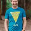 model wearing murmuration Mens teal T-shirt featuring a bike with a murmuration above. Model standing in a forest