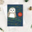 Christmas card featuring a barn owl sitting in a festive tree