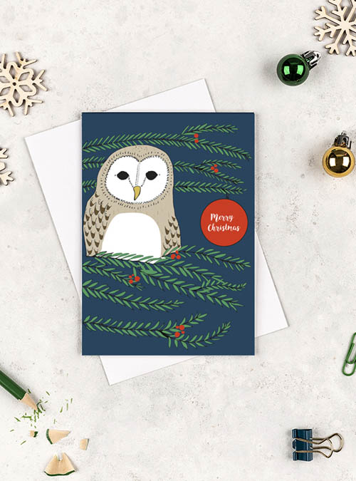 Christmas card featuring a barn owl sitting in a festive tree