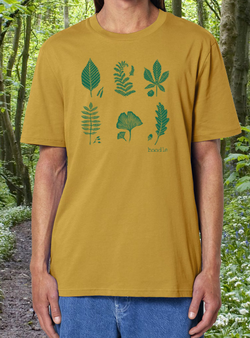 Model wearing mustard T-shirt featuring 6 leaves printed in green
