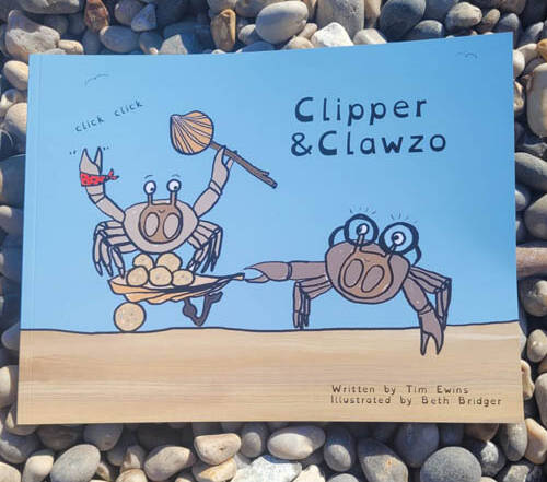 Childrens book 'Clipper & Clawzo" on the beach with pebbles as background