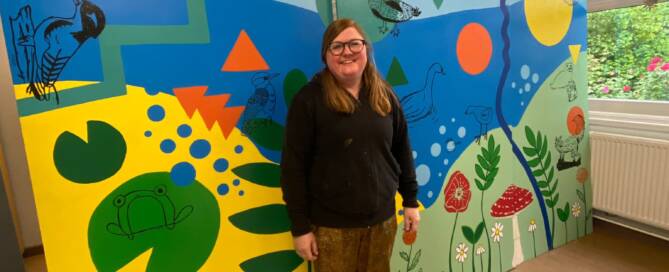 me standing in front of the finished mural for a local school
