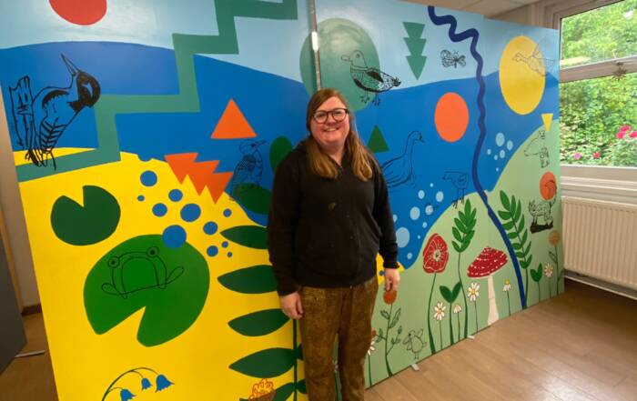 me standing in front of the finished mural for a local school