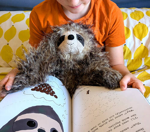 young girl reading book Sloth Moth with a sloth toy